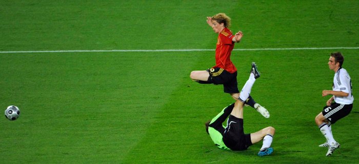 Fernando Torres se adelanta a Lahm y pica superando a Lehmann para lograr el gol español. / Reuters